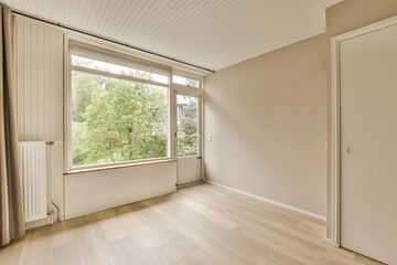 Fototapeta premium an empty room with wood flooring and large windows overlooking the trees in the distance are seen through the window