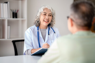 Female doctor writing prescription on clipboard while explaining medicine use and discussing about