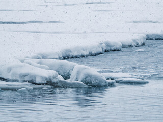 Photography of ice on arctic ocean. Drift ice floating on the surface of the northern sea. Gloomy snowy weather, white, blue colors, cold tone © Nostromo Trykowski