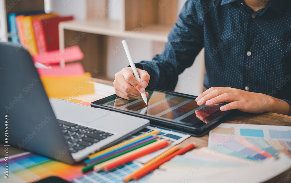 Poster graphic designer architects who work with laptops and color comparison tables for design work..