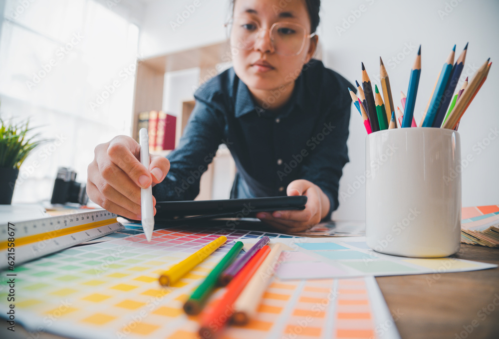 Poster graphic designer architects who work with laptops and color comparison tables for design work..