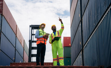 Foreman checking inventory or task details at Container cargo harbor. Logistics concept inside the shipping, import, and export industries.