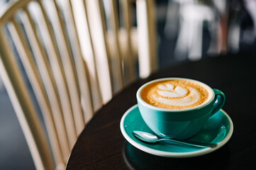 Coffee cappuccino in cup on wooden table in cafe