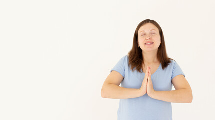 Fototapeta premium Worried young woman praying god with folded hands teenager girl asking god for help Pretty young business woman beg for mercy with eyes closed Isolated on white background