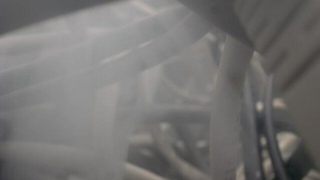 The camera lens traverses the maze of network cables and other obstacles. Complicated wires, computer problems, and the emergence of smoke implying a possible short circuit or fire.