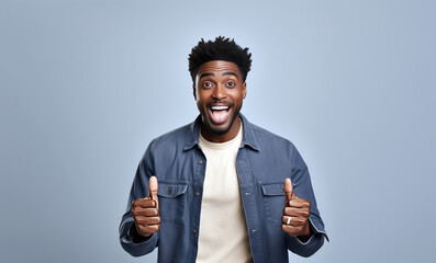 An young modern African American man looking directly towards the camera, with a two thumbs up gesture, looking very happy wearing casual clothing isolated on a plain blue background - Generative AI