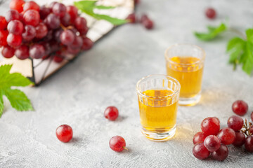 Grape vodka. Strong alcoholic drink in glasses on the table. Fresh grapes