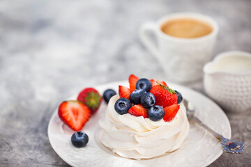Delicious Pavlova meringue cake decorated with fresh strawberry and blueberry