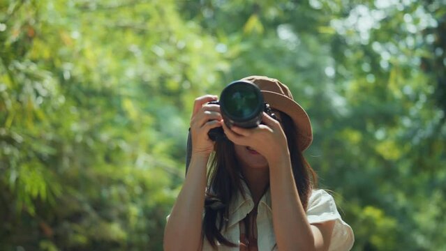 Asian woman traveller enjoy vacation moment while taking photos of nature with camera, Female hands holding camera and doing nature photography, Travel Blogger Photographing.