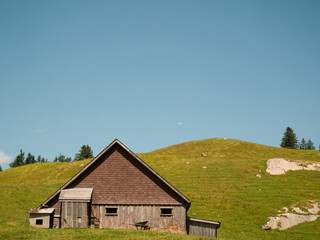 Fototapeta na wymiar Swiss Mountain Cabin on a sunny Hillside