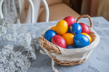 Fototapeta na wymiar easter bright colored eggs in the easter egg basket. Festive Easter multicolored eggs on a wooden background