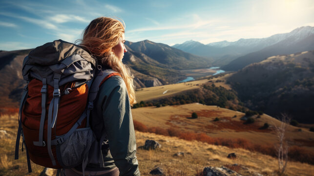female hiker with backpack looking out over a landscape