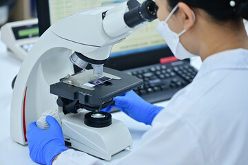 Naklejka na ściany i meble Medical Science Laboratory: Portrait of a scientist looking under a microscope without analyzing a test sample. Ambitious young biotechnologist working with advanced equipment.
