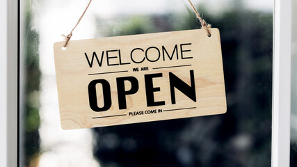 Open sign broad through the door glass and ready to service. Small business woman owner turning the...