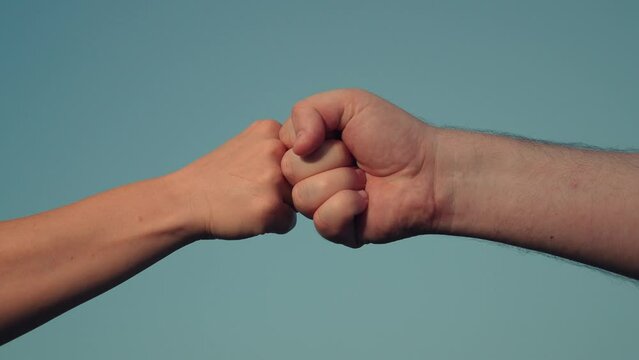 Male and woman fists against sky, trust, harmony, friendship. Fist to fist sign, expresses consent, gesture of respect. Teamwork concept. Lifestyle business team clenching their fists, Hands closeup