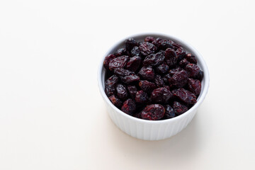 Superfood Heap Of Dried Cranberries In White Bowl On Beige Background. Selective Focus. Sweet Dehydrated Cranberries. Nutrients And Vitamins. Horizontal And Copy Space. 