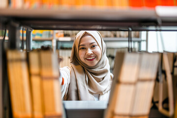 Young asian muslim woman in a library
