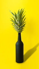 Creative summer layout made of pineapple fruit leaves and elegant black bottle against vibrant yellow background. Minimal summer concept. Tropical vibes. Welcome summer.