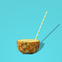 Creative tropical layout with pineapple and drinking straw against pastel blue background. Minimal summer concept. Food art.