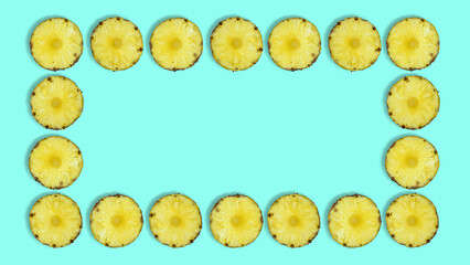 Creative summer pattern made of pineapple rings against pastel blue background. Original pineapple decoration. Creative summer idea. Fruit art. Copy space. Pineapple frame.