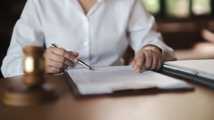  Labor law concept. Lawyer signing legal document with Judges gavel.