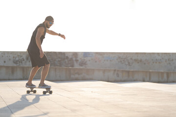 Adult attractive man skateboarding on the street