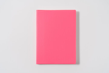 Pink notebook on white desk. Business minimal concept for women. Flat lay, top view, copy space