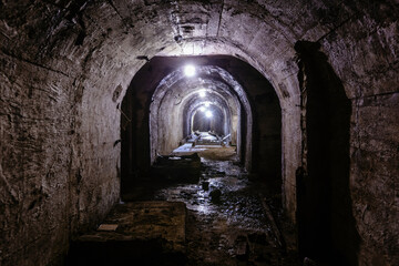 Fototapeta premium Vaulted tunnel with concrete walls in old abandoned bunker, mine, drainage, subway, etc