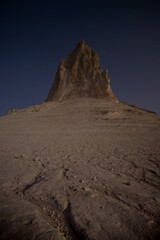 Chalk and limestone remnants in the Kazakh steppe at night against the background of the starry sky and the moon, vertical landforms after weathering in the desert