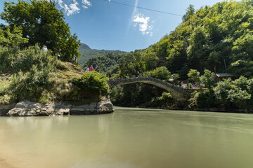 Tourists visiting arc stone bridge of Queen Tamar in Adjara, Georgia. Historical landmark. Old...