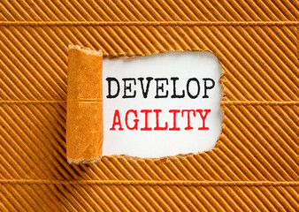 Develop agility symbol. Concept words Develop agility on beautiful white paper on a beautiful brown paper background. Business, support and develop agility concept. Copy space.