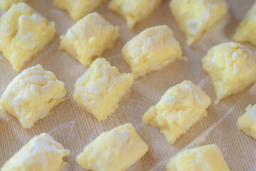Sweet curd dessert. Sliced pieces of dough lie on the table in flour. View from above. Recipe for a delicious dessert at home.