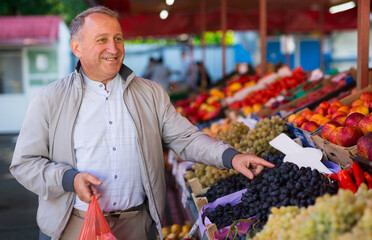 Middle aged man buying fruits