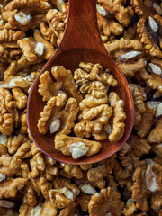 Peeled walnut lies in wooden spoon. Top view. Advertising photo for selling nuts on marketplaces. Useful nutritious nut.