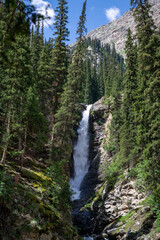 Waterfalls in the Barskoon Gorge among trees and mountains, stones, Manas Bowl, Tears of Bars in Kyrgyzstan