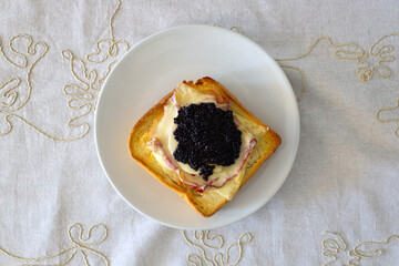Toast bread with knife on a plate on the wooden table