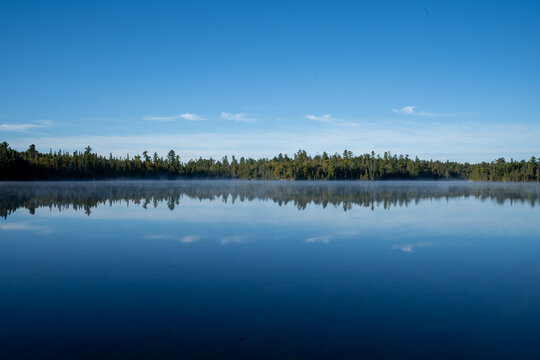 Morning sun reflecting off calm lake in Temagami Ontario Canada