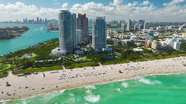 Aerial view of South Beach sandy surface with tourists relaxing on hot Florida sun. Miami Beach city with high luxury hotels and condos. Tourism infrastructure in southern USA