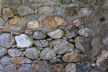 Texture of Old fence wall made of large river stones and concrete