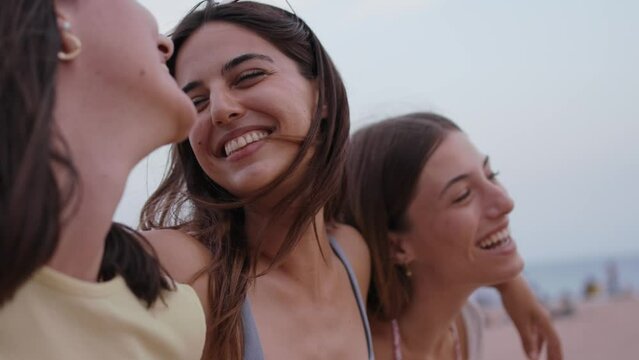 Group of beautiful young attractive female friends walking embracing happy on beach. Laughing Caucasian girls enjoying summer vacation outdoors. People having fun on vacation in Mediterranean. 