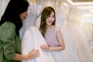 Naklejka premium Female bridal store owner work in wedding studio shop. Owner Of Bridal Wedding Dress Shop Work in shop. Designer woman working wedding dress in store..