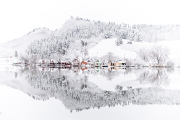 lakeside cottages in snowy winter landscape