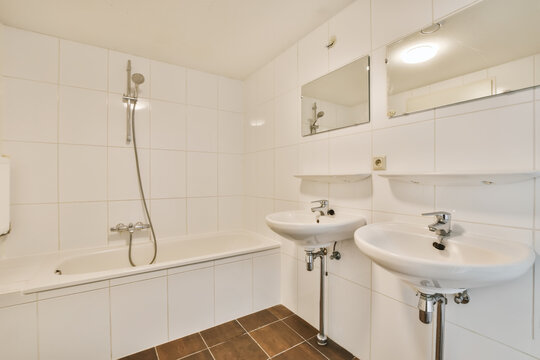 a bathroom with two sinks and a mirror on the wall behind it is an open shower stall, which has been used as a