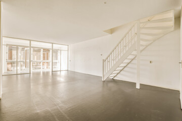 an empty living room with stairs leading up to the second floor and glass doors that lead out onto the balcony