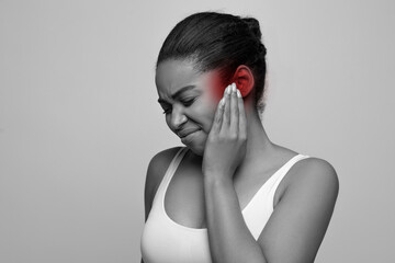 Sick young black woman touching her painful ear, copy space