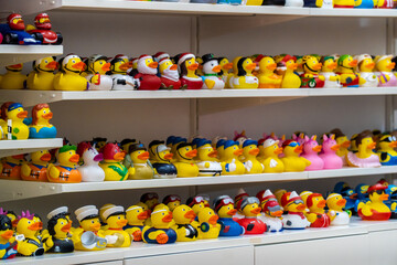 Toy rubber ducks with different characterizations, on a store shelf.