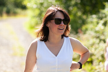 Portrait of a middle-aged woman in a white shirt and sunglasses