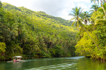 Exotic cruise boat with tourists on a jungle river Loboc, Bohol