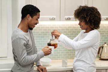 Beautiful millennial african american couple enjoying tea together
