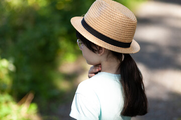 Portrait of asian little girl wearing straw hat and glasses.
